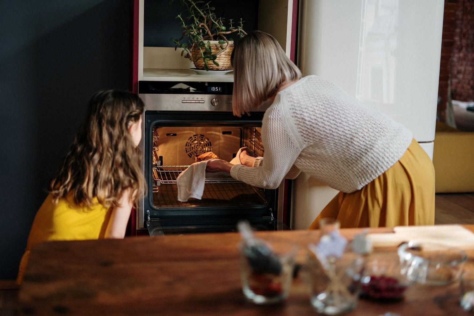 Vrouw stopt eten in een voorverwarmde oven | Welhof NL